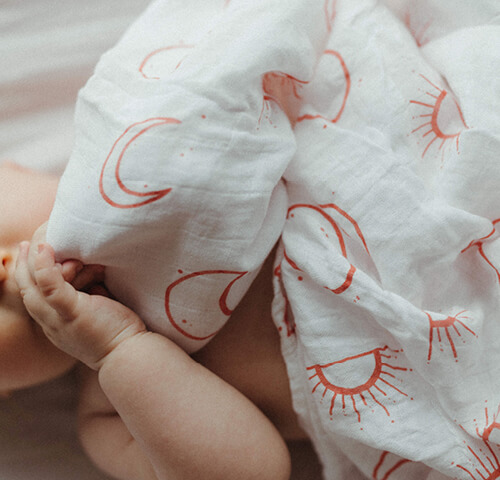 baby with muslin wrap