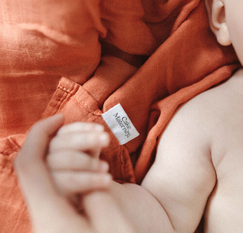 baby's hand in muslin wrap
