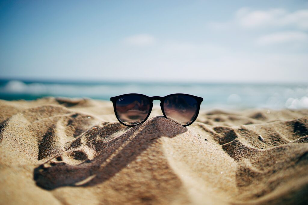 black sunglasses on the sand