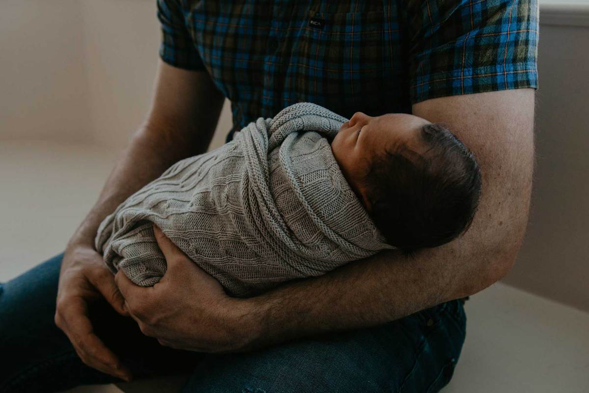 man sitting holding a baby