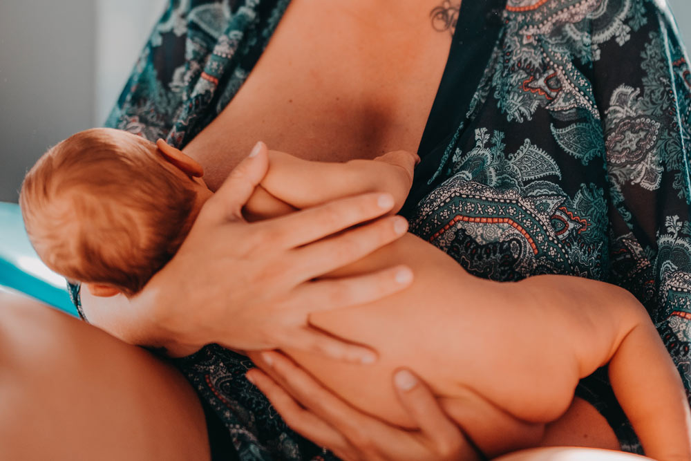 mother sitting in bed holding her baby