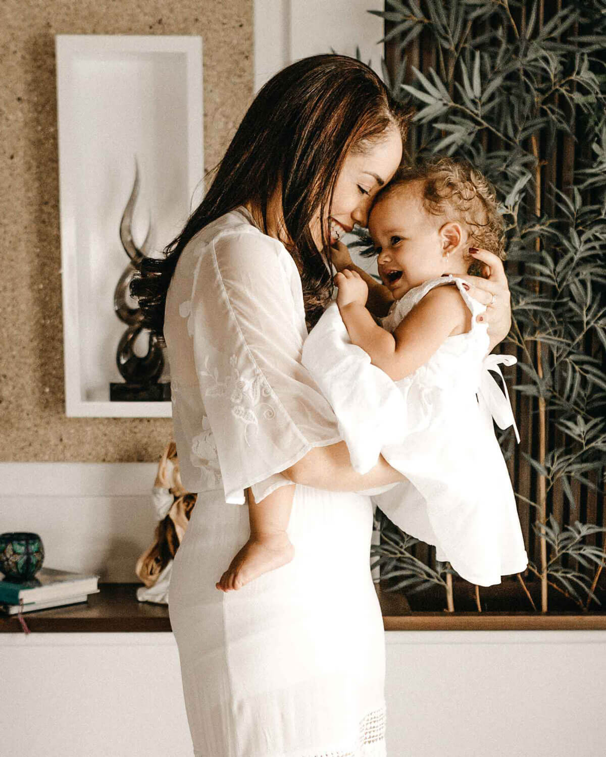 mother and daughter smiling in white dress