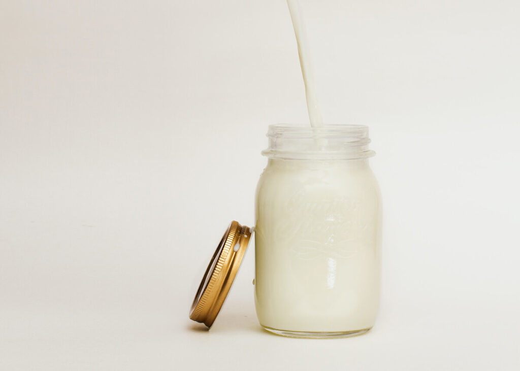 pouring millk in a glass jar