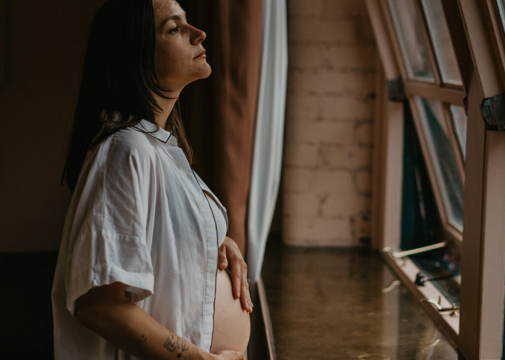 pregnant woman facing the window