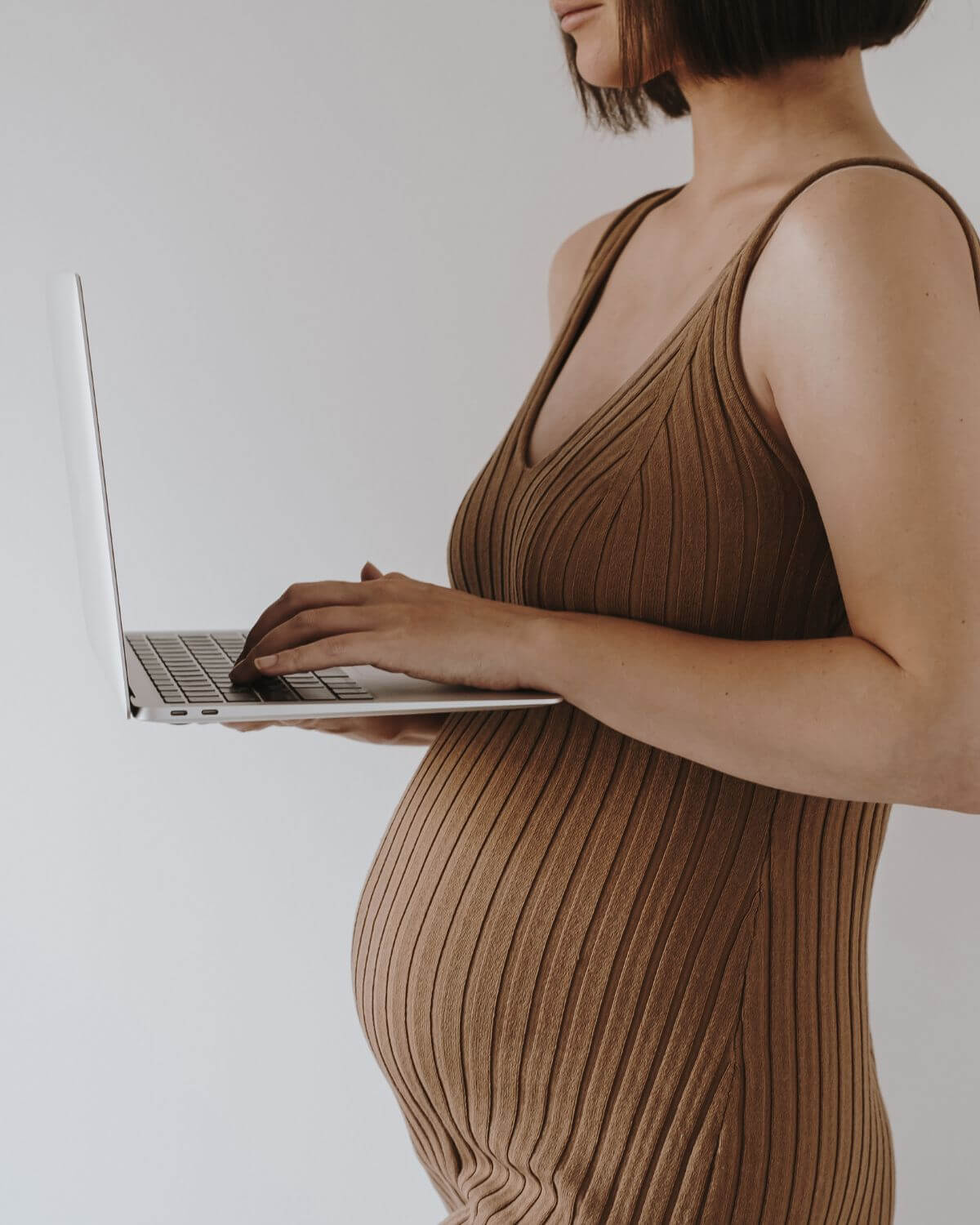 pregnant woman holding a laptop