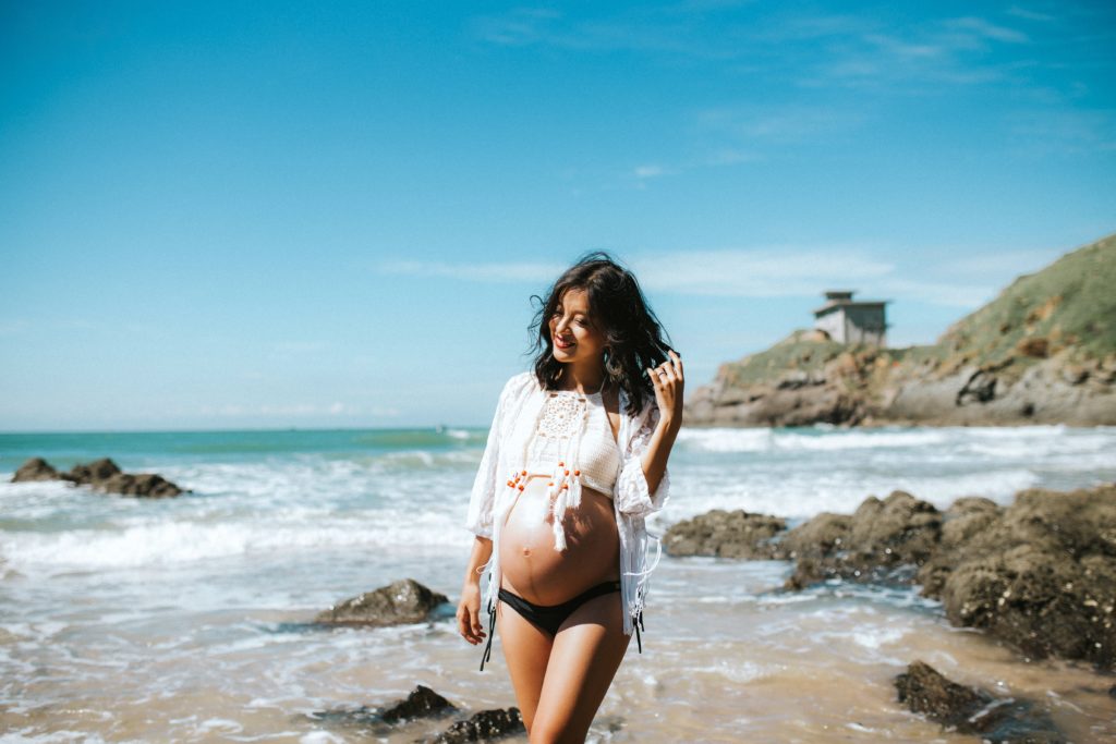 pregnant woman walking on the beach