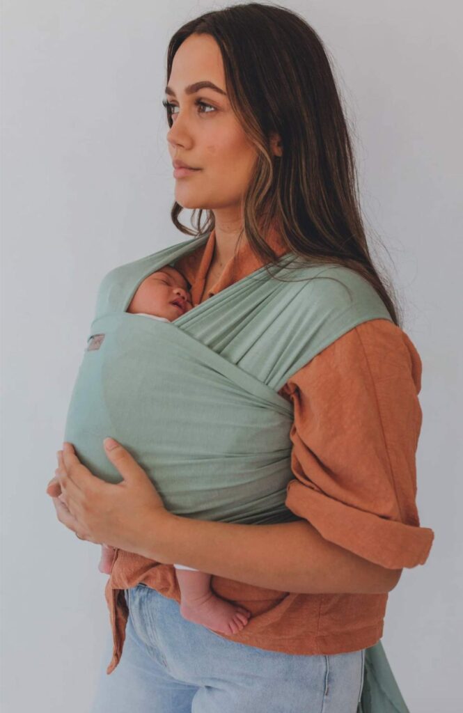 woman holding her wrapped baby